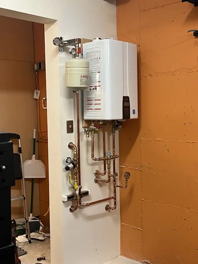 Plumbing technician inspecting water heater connections in Portland